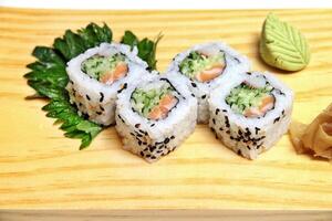 Traditional Uramaki, Japanese delicacy with nori, sesame, rice vinegar, kani kama and Japanese cucumber photo