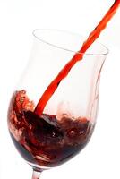 red wine being served in a glass on a white background photo