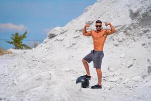 atlético joven hermoso top-less chico. sin camisa muscular hombre al aire libre posando foto