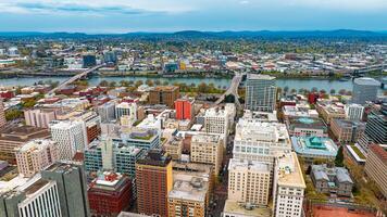 Downtown of Portland, Oregon, the USA with high-rise architecture. Twilight view of the city with mountain silhouettes at backdrop. photo