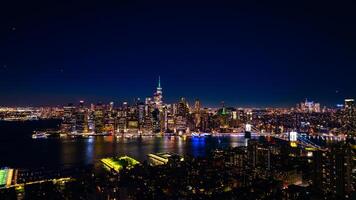 Distancing from a spectacular view of New York, the USA on the waterfront of the East River. Skyline of metropolis at night. Aerial perspective. photo