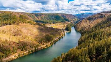 Spectacular view of mountains and river in the wilderness of Oregon State, the USA. Mt. Hood National Forest. Grey rainy clouds overcast the sky above the landscape. Top perspective. photo