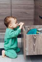 Small kid sitting with open shelf. Little playful child room. photo