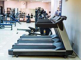 moderno gimnasio interior con equipo. aptitud club con fila de cintas de correr para aptitud y cardio formación sano estilo de vida concepto. foto