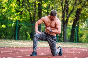 Muscular shirtless man training outdoor. Lifestyle handsome bodybuilder. photo