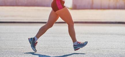 Fitness woman running in sportswear on city road photo