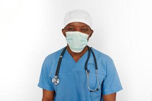 Black surgeon doctor man in blue coat white cap and surgeon mask with stethoscope white background photo