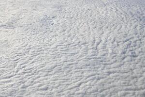 Breathtaking over clouds view from aircraft window, thick white blue clouds looks like soft foam photo