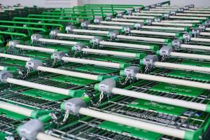 Row of parked trolleys or shopping carts in supermarket photo