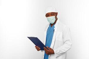 Black surgeon doctor man in white coat cap and surgeon mask holds medical records with diagnosis photo