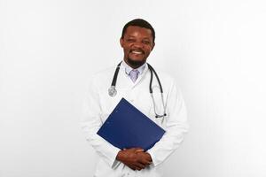 Smiling black bearded doctor man in white robe holds medical clipboard, isolated on white background photo