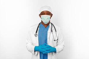 Black surgeon doctor man in blue white coat blue gloves white cap and surgeon mask with stethoscope photo