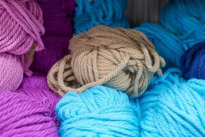 Multicolored blue green yarn balls in knitting shop, macro photo