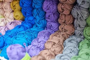 Yarns or balls of wool on shelves in store for knitting photo