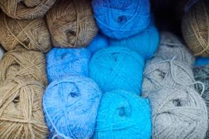Colored blue brown yarn balls in knitting shop, macro photo