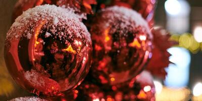 adornos de árboles de navidad cubiertos de nieve, árbol de navidad al aire libre con bombillas rojas decorativas foto