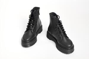 Black women combat boots on high heel platform with lug soles on isolated white background photo