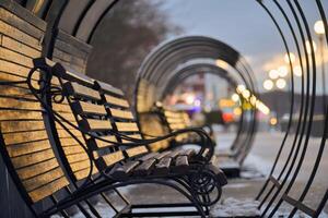 Wooden benches in lantern light in winter city park photo