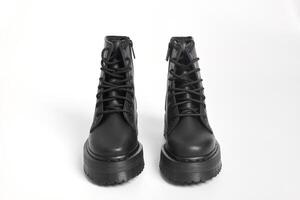 Black women combat boots on high heel platform with lug soles on isolated white background photo