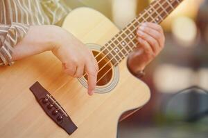 Man playing acoustic bass guitar at outdoor event, close up view to guitar neck photo