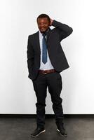 Confused smiling african american black man in business suit full size portrait white background photo