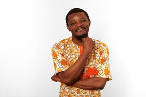 Thoughtful smiling black man in African bright clothes isolated on white background, pensive man photo