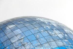 Glass spherical modern building with reflection of blue sky photo