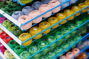 Yarns or balls of wool on shelves in store for knitting photo