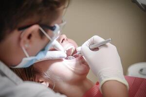 A dentist doing scaling to a young boy photo