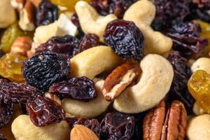 background with a cashew, hazelnuts, raisins and peanuts. Mixed nuts and raisins texture. photo