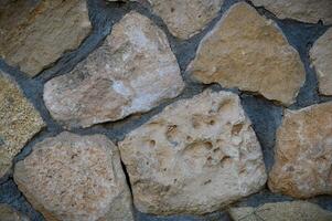 Granite stones of different shapes and colors. Wall cladding. Background selective focus with copy space. 1 photo