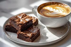 Cup of coffee with latte art with brownies on wooden table and morning sunlight with shadow through from window. Beautiful meal with warm sunlight. photo