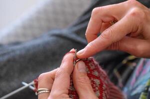 woman sitting on sofa, skillfully knitting warm socks 2 photo