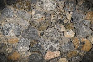 grey stone dark wall of medieval horizontal stones facade background photo