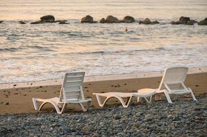 beach loungers in the setting sun in the evening 1 photo