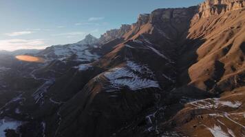 flyg av en gam i de vild natur av de highlands av de Kaukasus. en fågel av byte hög i de himmel mot de bakgrund av bergen och de miljö Sol. video