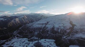 Flight of a vulture in the wild nature of the highlands of the Caucasus. A bird of prey high in the sky against the backdrop of mountains and the setting sun. video