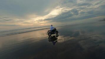 motociclista equitazione su nero spiaggia su motociclo video