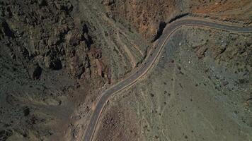 Motorcyclists are driving on a mountain road, drone view video