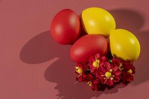 Colorful eggs, symbolizing Easter, on a colorful background and flowers photo