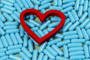 heart shape and blue capsules. Importance of medication treatment photo