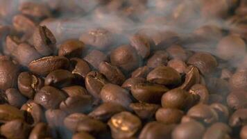 Slow mation of roasted coffee beans with smoke. Organic coffee seeds. video