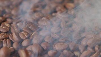 Slow mation of roasted coffee beans with smoke. Organic coffee seeds. video