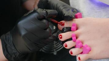 vrouw schoonheidsspecialist aan het doen procedure pedicure en is van toepassing rood nagel Pools video