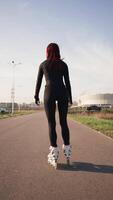 Rear View Slim Woman with Beautiful Figure Rollerblading on Asphalt in City Park video