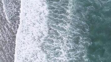 Drone upward shot of waves breaking on the shore of a beach. Top view footage video