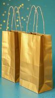 Golden Shopping Bags on a Sparkling Teal Background photo