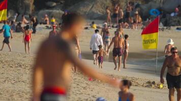 PHUKET, THAILAND - NOVEMBER 18, 2019. People on the beach of Phuket island at sunset. Tourists sunbathe, swim, play video