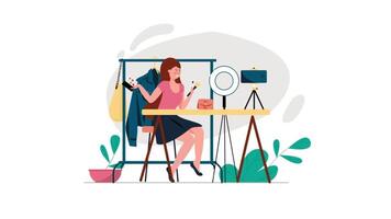 a woman is sitting at a desk with a camera and a mirror video