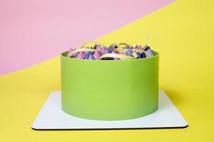 Close-up of mousse cake decorated with chocolate tulip, close up, yellow and pink background photo